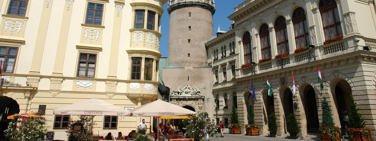 The Firewatch Tower rising above Sopron's main square, flanked by the pastel Baroque facades of the Storno House and Town Hall
