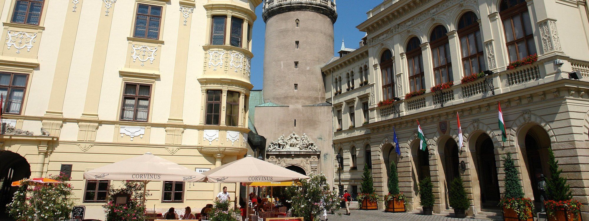 The Firewatch Tower rising above Sopron's main square, flanked by the pastel Baroque facades of the Storno House and Town Hall