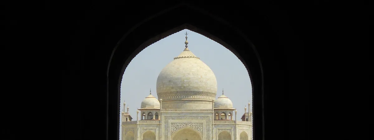 The Taj Mahal's dome framed by the pointed arch of the Darwaza-i Rauza, its main gateway
