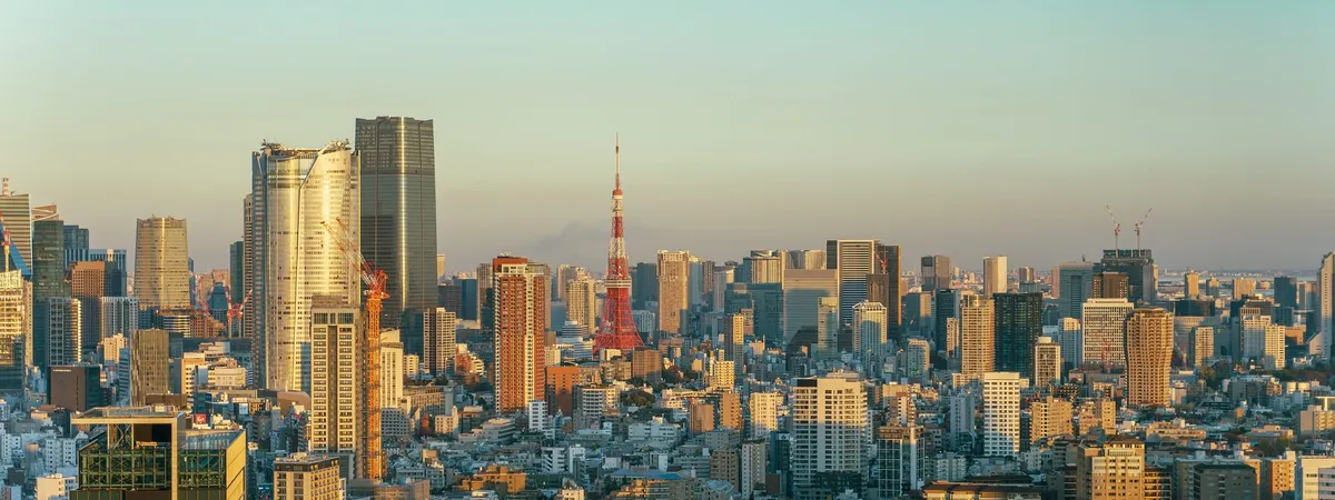 Tokyo Tower lit up at sunset above the Minato City skyline
