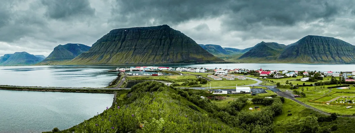 Ísafjörður spread along its sandspit in Skutulsfjörður under a flat-topped fjord mountain, with the harbour on one side and the fjord on the other