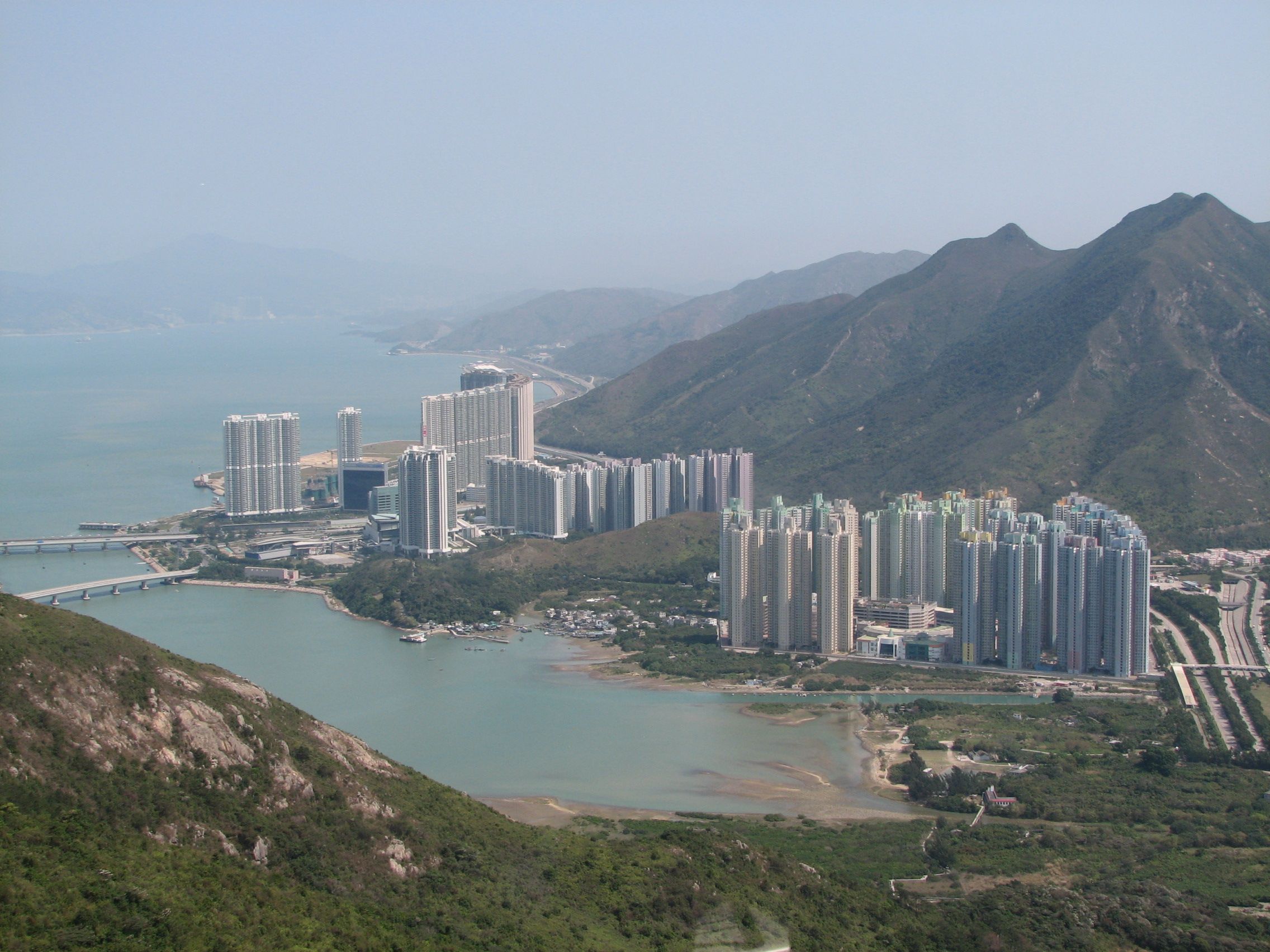 Aerial view of Tung Chung new town between the mountains and the sea on Lantau Island, seen from the Ngong Ping cable car