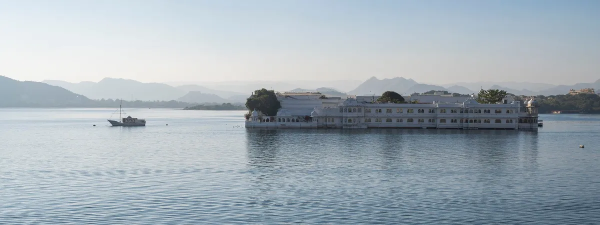 The Taj Lake Palace floating on Lake Pichola at sunrise, seen from the City Palace