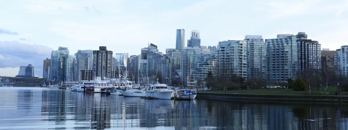 Vancouver's downtown skyline and marina reflected in the calm water of Coal Harbour