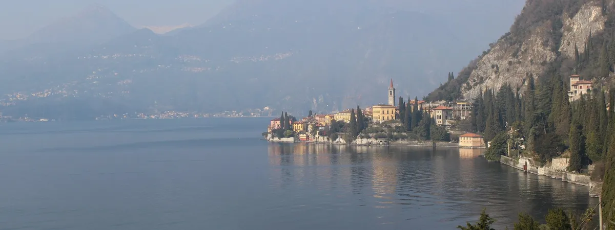 Varenna’s coloured houses and bell tower on their headland above Lake Como, with the mountains of the western shore behind