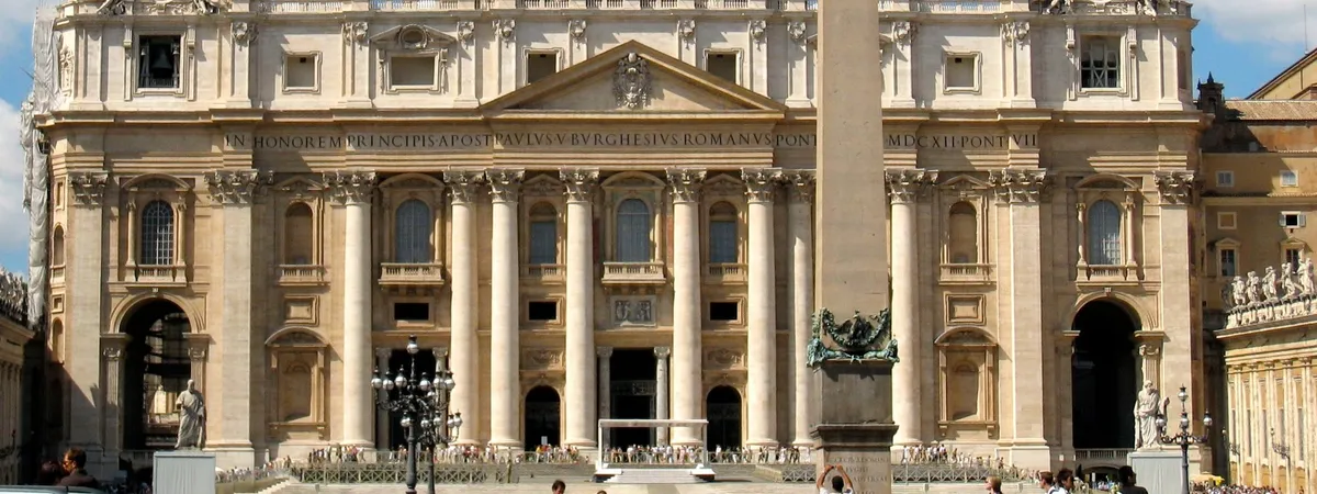 The facade of St. Peter's Basilica and the obelisk in St. Peter's Square, seen from the piazza with crowds gathered below