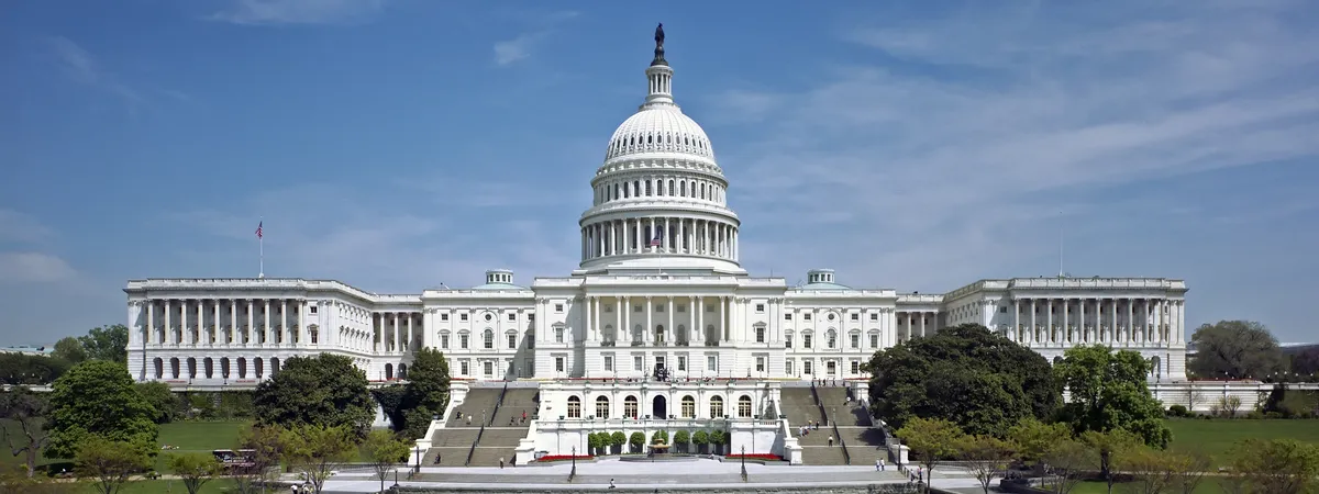 The west front of the United States Capitol building and its dome, seen across the lawn on a clear day
