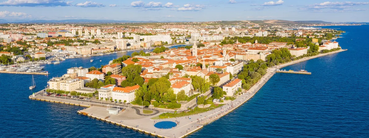 Aerial view of Zadar's Old Town peninsula with the Sea Organ and Greeting to the Sun at the waterfront tip